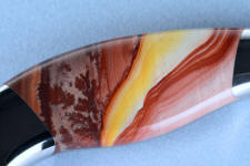 This Hickoryite Rhyolite gemstone knife handle shows bright yellows, oranges, reds and pinks with some dendtiric forms and flowing bands. It's extremely durable and hard, taking a bright glassy polish This Hickoryite Rhyolite gemstone knife handle shows bright yellows, oranges, reds and pinks with some dendtiric forms and flowing bands. It's extremely durable and hard, taking a bright glassy polish